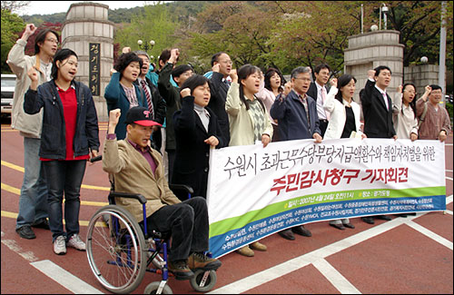 수원시 공무원들의 초과근무수당 부정 수급과 관련해 시민공대위 소속 관계자들이 경기도청 정문 앞에서 기자회견을 열고 수원시 규탄구호를 외치고 있다. 